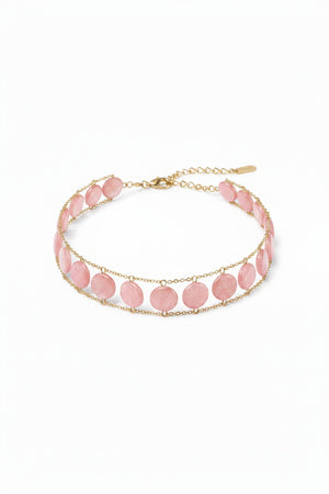 A close-up of a woman's neck wearing the GOLDISH Ladders to Bliss Pink Moonstone Choker, featuring two rows of round moonstones set in gold-toned chain links, by GOLDISH, against a neutral background.