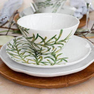 The VIETRI - Fauna Cereal Bowl is a small, white ceramic piece adorned with delicately painted green leaf designs on the exterior, evoking the lush greenery of Umbria. This bowl features a simple, elegant shape with a slightly flared rim and a smooth finish.