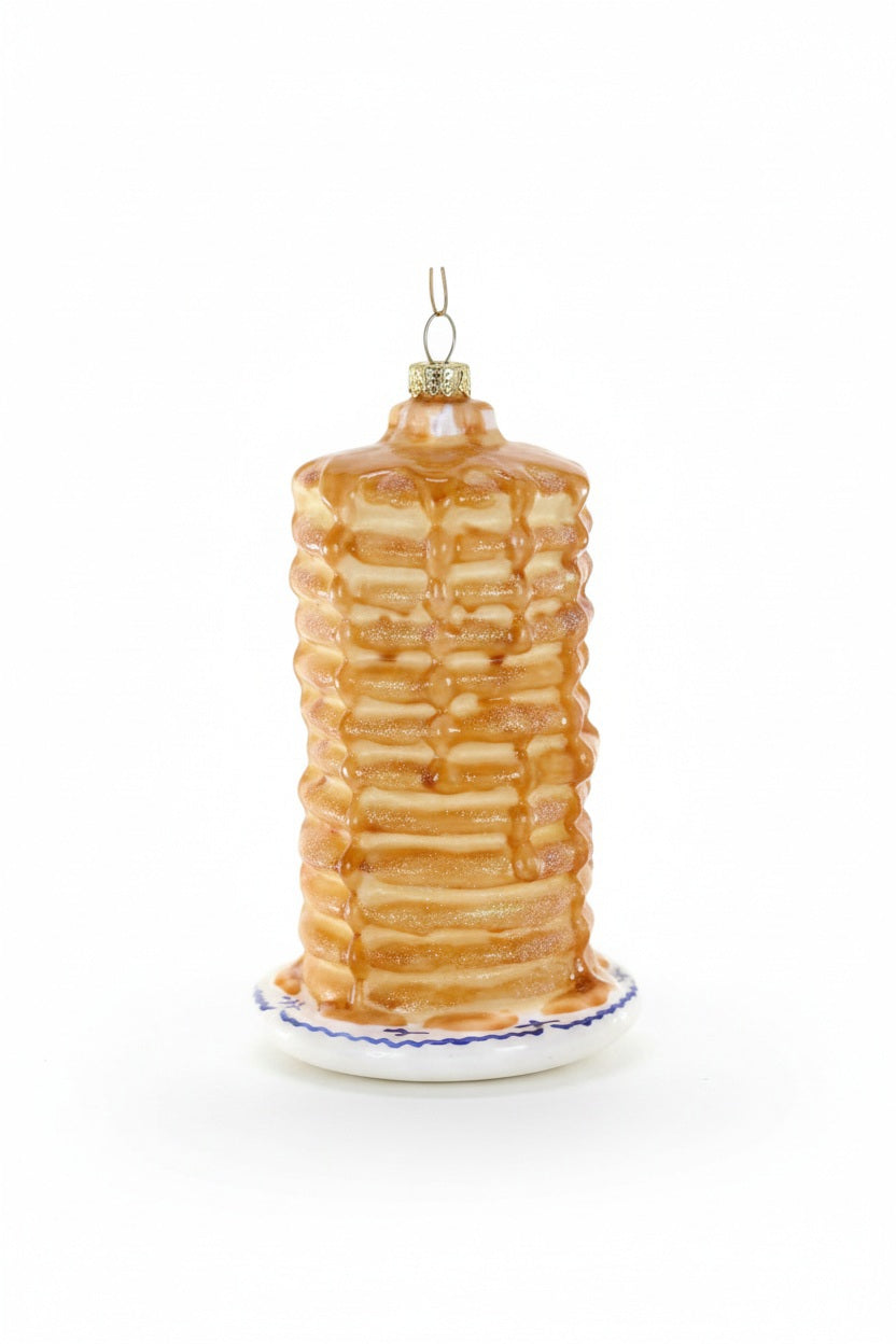 The BIG STACK ORNAMENT by CODY FOSTER is a delightful Christmas tree decoration shaped like a tall stack of pancakes with syrup on a white plate with a blue rim, gold cap, and hanging loop—perfect for collectors or as a unique holiday gift.