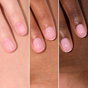 A pink serum drop labeled with its ingredients: raspberry extract (strengthens nails), AHAs (restore and harden), and sweet almond oil (nourishes). The text highlights that MANUCURIST - ACTIVE GLOW CARE POLISH by MANUCURIST INC is 85.5% plant-based—making it the ideal nail strengthener for achieving healthy, glass-like nails.