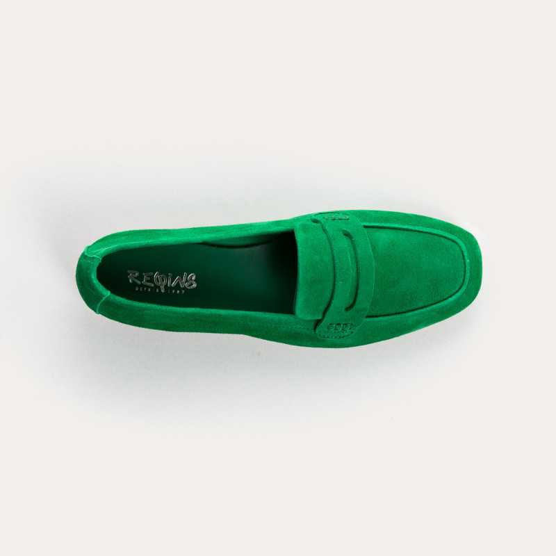 A person stands on a light floor wearing blue jeans and REQINS - HEMA SUEDE LOAFER IN GAZON GREEN by REQINS, featuring a leather insole.
