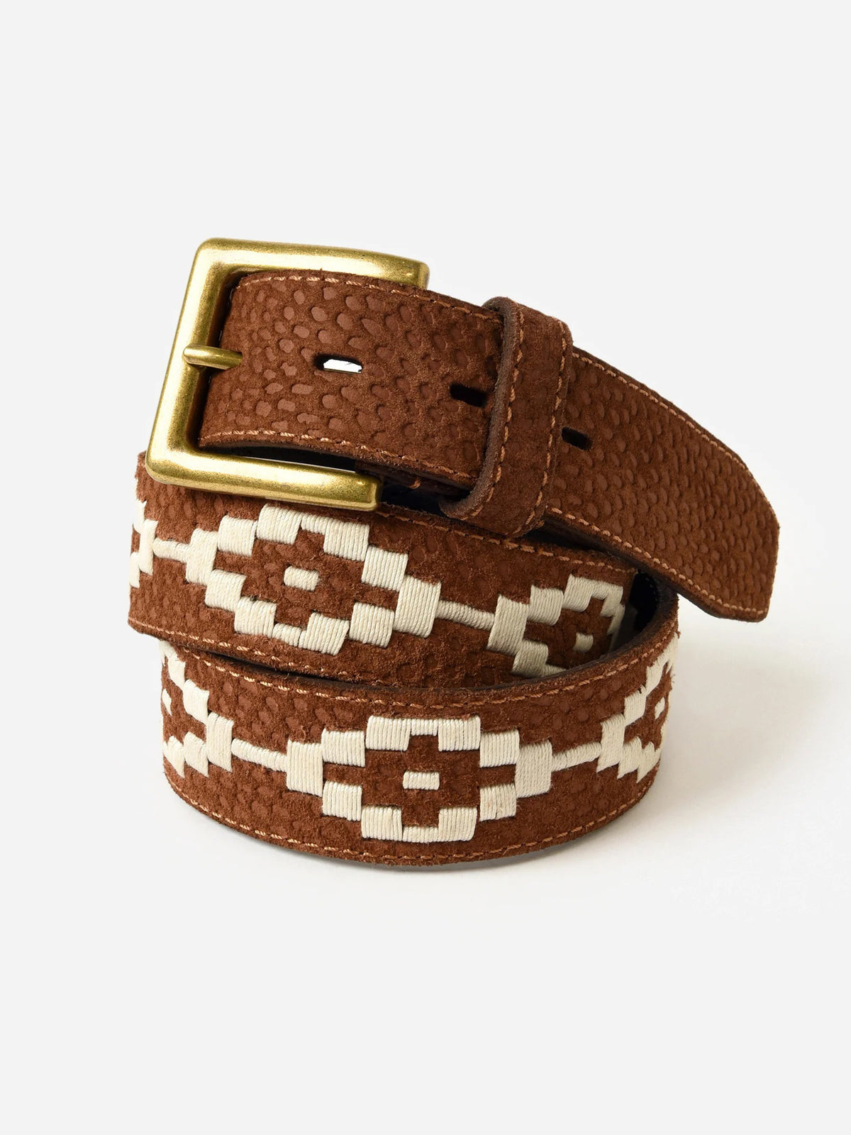 The LA MATERA - EL CAMPO POLO BELT by LA MATERA features brown saddle leather, a gold buckle, textured surface, and white hand-embroidered geometric patterns, coiled neatly against a white background.