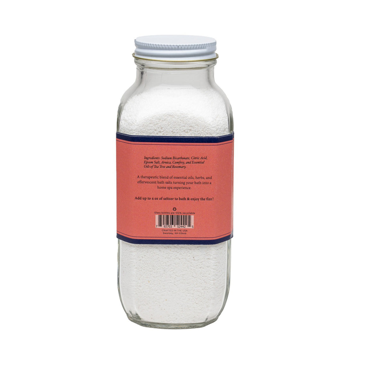 A clear glass bottle labeled &quot;BAUDELAIRE - RECOVER BATH SELTZER 18OZ&quot; with a red and white label. The label highlights that it is handmade, therapeutic, features an effervescent formula, contains all-natural essential oils, and weighs 18 ounces.
