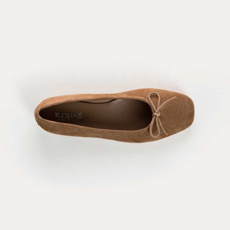 The REQINS - HARMONY SUEDE BALLERINA FLATS IN NATURAL by REQINS feature a small front bow and classic design, shown from the side against a plain light background—an essential wardrobe staple.
