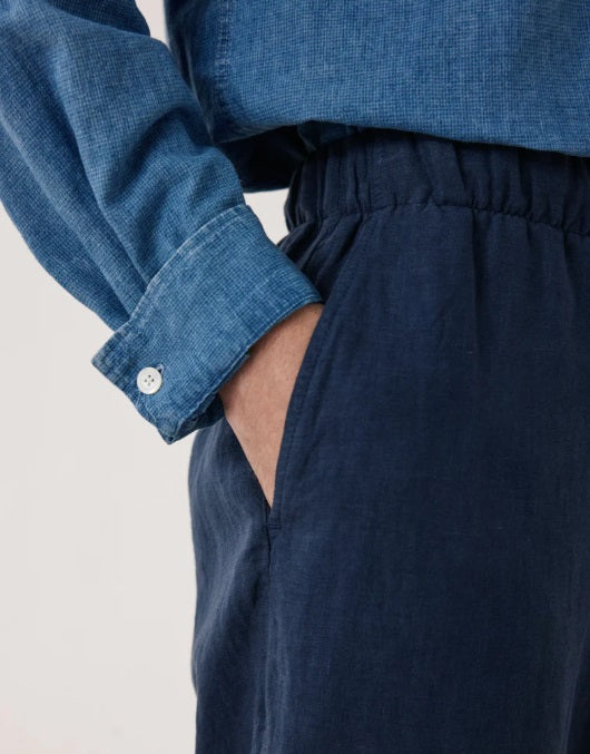 HARTFORD Linen Joggy Pants in Navy feature an elastic waistband, drawstring, side pockets, and a relaxed fit. Crafted from breathable linen by HARTFORD, these joggers are showcased on a plain background.