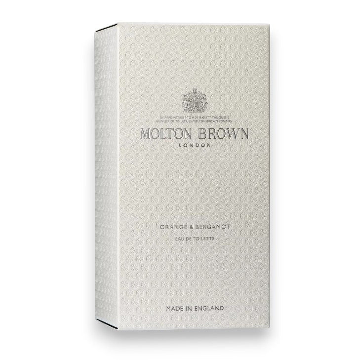 A bottle of MOLTON BROWN - ORANGE AND BERGAMOT EAU DE TOILETTE, with Sevillian orange and neroli notes, features a round black cap and clear glass revealing the light yellow fragrance inside.