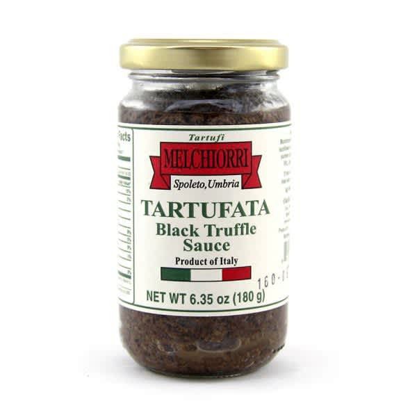 A jar of MELCHIORRI - BLACK TRUFFLE SAUCE by ATALANTA CORPORATION is shown. The jar has a red and white label indicating it's a product of Italy, specifically from Umbria. Weighing 6.35 oz (180g), this exquisite pasta sauce features the rich flavors of summer truffles for a gourmet touch to your dishes.