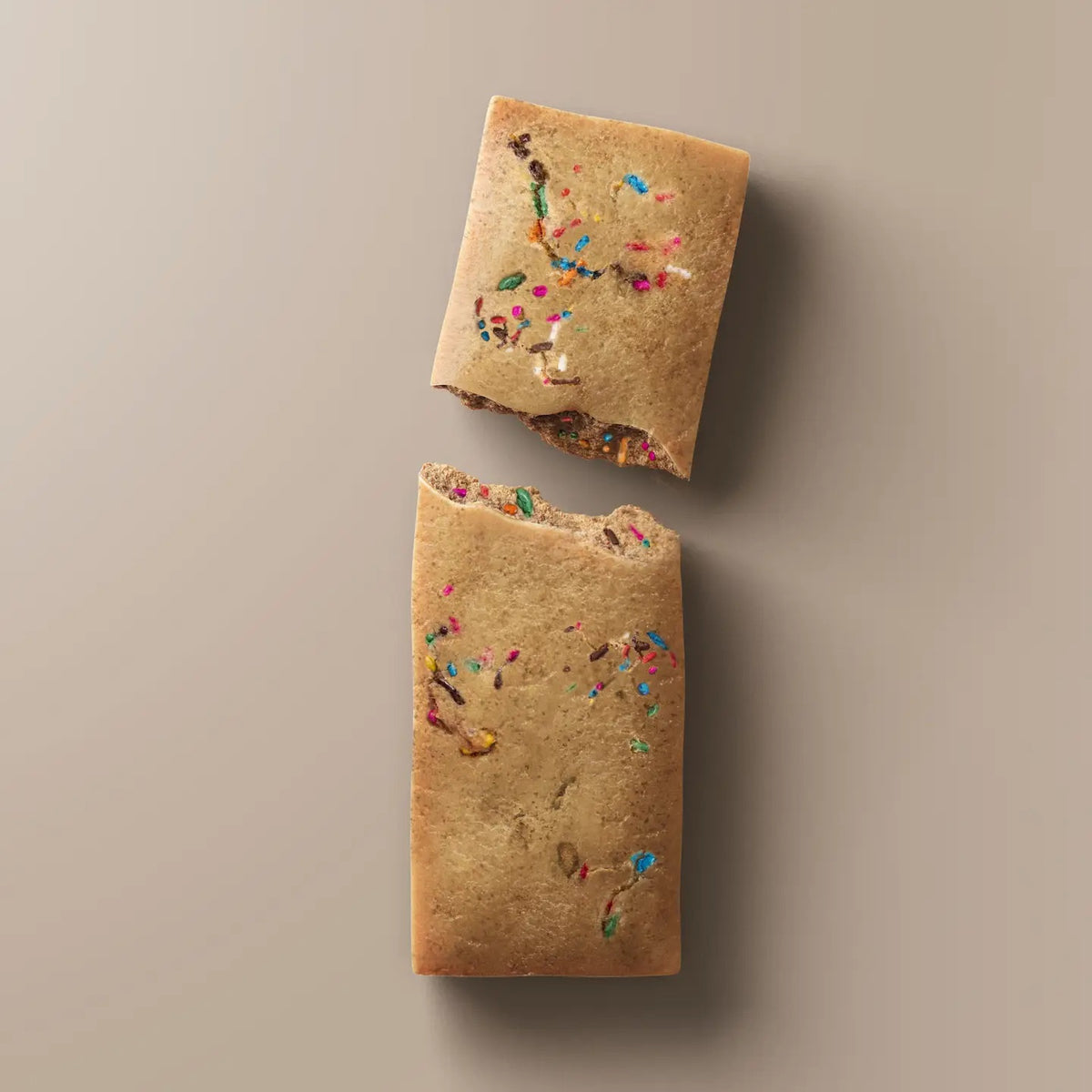 A wrapped STARS+HONEY - BIRTHDAY CAKE CHOCOLATE CHIP bar rests on a beige surface. The light blue packaging, branded with the STARS+HONEY logo and white text, displays nutrition details and hints at the irresistible flavors of vanilla yellowcake and natural sprinkles inside.