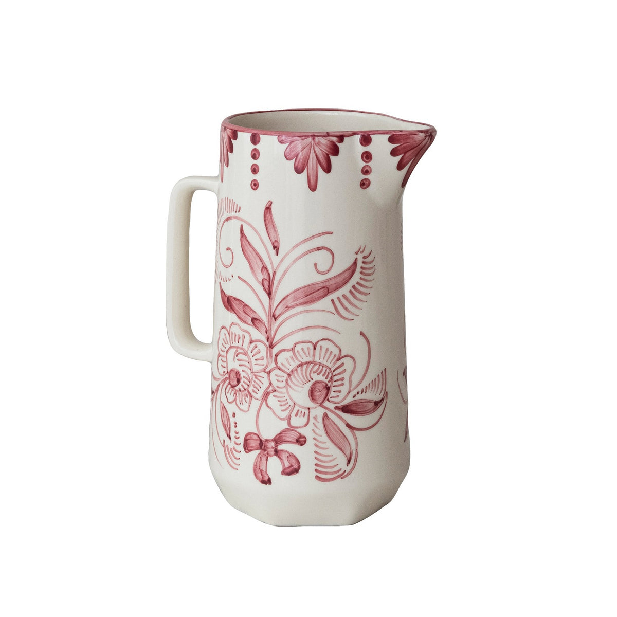 The HAND-PAINTED STONEWARE PITCHER WITH BOTANICAL DESIGN by CREATIVE COOP features a white ceramic finish, handle, and pink floral and swirl patterns with decorative dots, capturing charming cottagecore style on a plain background.