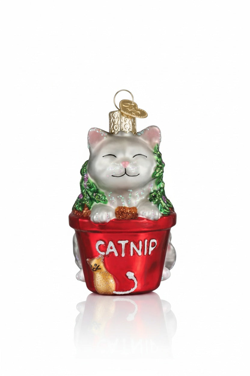 An OLD WORLD CHRISTMAS CATNIP CAT ORNAMENT shaped like a mellow white cat sitting in a red flower pot labeled “CATNIP” with a small cat icon on the front.