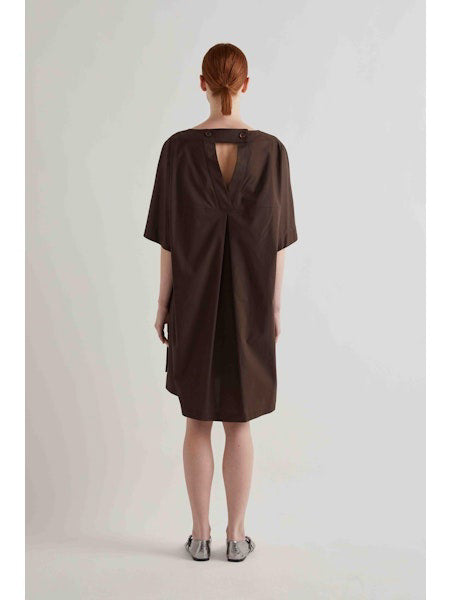 A person with straight red hair stands against a plain light background, wearing the MEIMEIJ oversized cotton shift dress in black by MEIMEIJ and silver flat shoes.