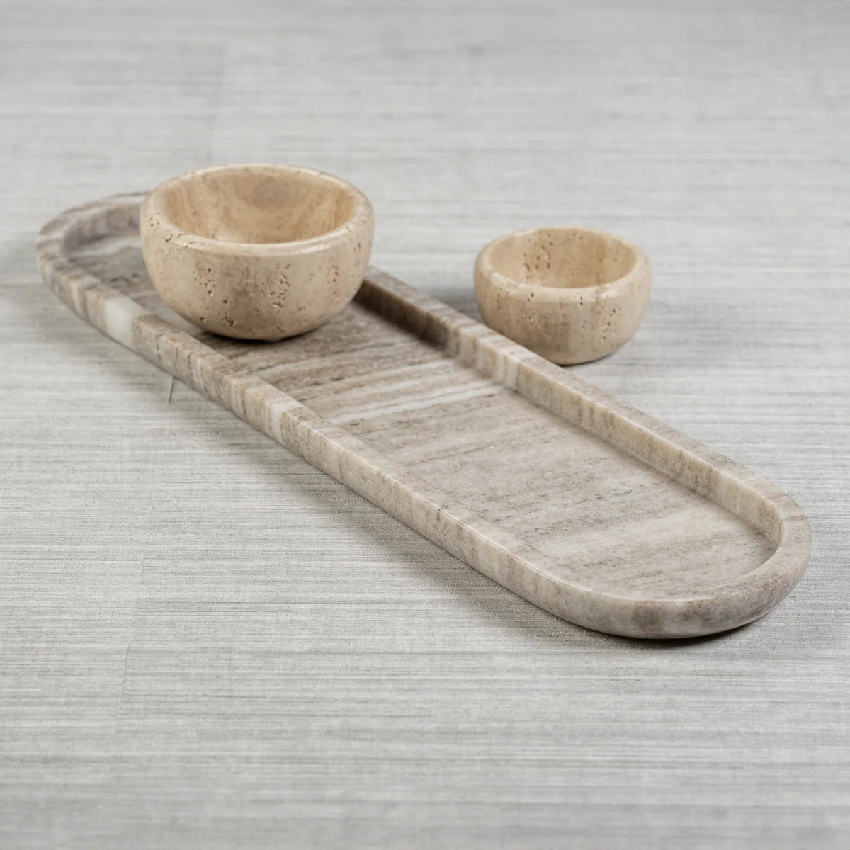 The MARBLE OASIS TRAY by ZODAX is an elegant, long oval marble tray featuring subtle gray and white veining, beautifully displayed on a white background.