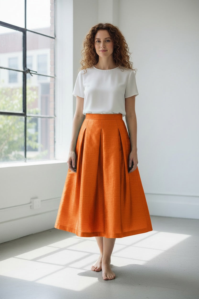 The MIDI STRUCTURED SKIRT by ALYKI LABORATORIO is a high-waisted, midi-length piece with a flared silhouette, showcasing a vibrant pink and red abstract floral print on a white background.