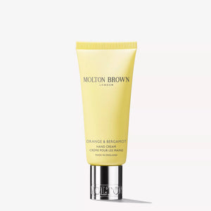A yellow tube of MOLTON BROWN - ORANGE & BERGAMOT HAND CREAM with a silver cap, featuring fresh citrus musk notes, stands upright on a white background.