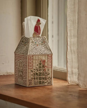 HOME FOR THE HOLIDAYS TISSUE BOX COVER shaped like a house, featuring an embroidered Christmas tree, string lights, and a teddy bear in a Santa hat for festive holiday home decor.