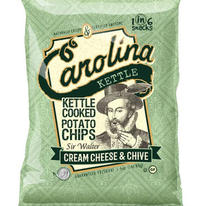 A bag of CAROLINA KETTLE - CREAM CHEESE AND CHIVE CHIPS by 1 IN 6 SNACKS features a vintage illustration of Sir Walter Raleigh. The enticing flavor combination is Cream Cheese & Chive. The packaging design is green with white and dark green text, and includes "Gluten Free" and "1 in 6 Snacks" labels.