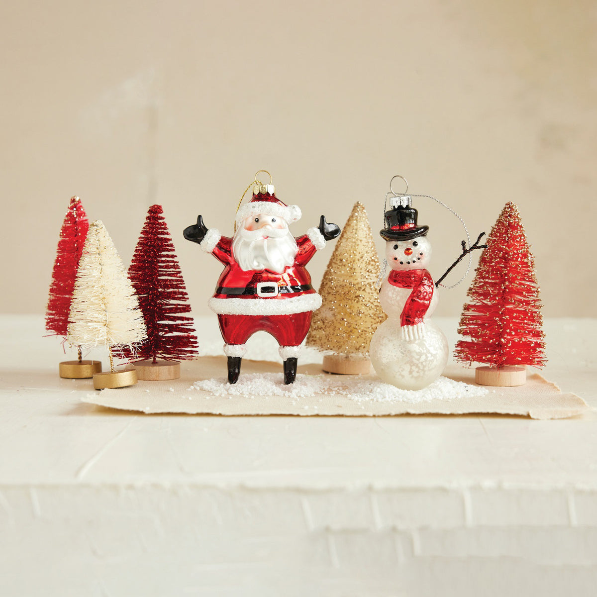 The CREATIVE COOP Mercury Glass Snowman Ornament features a red scarf, black top hat, and twig arms, and hangs from a silver string against a white background.