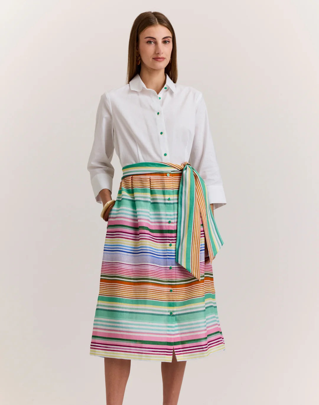 A woman wears the HINSON WU Robin 3/4 Sleeve Linen Dress in Multi Stripe, featuring breathable fabric and a matching tie belt, standing against a plain light background.