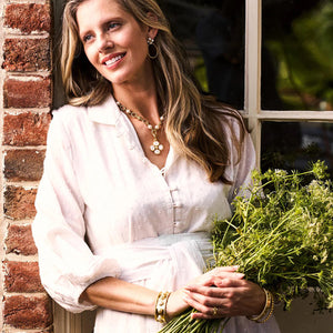 The CAPUCINE DE WULF - BERRY CLOVER DOUBLE SIDED PENDANT features a gold clover design with a textured, dotted surface and mother of pearl center. It includes a twisted loop for chain attachment.