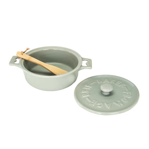 Set of two CREATIVE COOP stoneware brie bakers with lids—one gray, one white—each featuring handles and a matching wooden spreader tied on top.