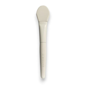 THE BRUSH by U BEAUTY is a white silicone skincare applicator featuring a flat, rounded tip and "U BEAUTY" on the handle—crafted for precision application against a clean, white background.