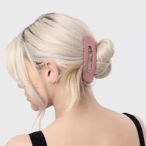 A pink card presents the KITSCH - FLAT LAY CLAW CLIP 3 PCS, featuring three clips in gradient shades of pink and mauve, from light to dark. Adorned with a logo and text, it emphasizes their crafting from recycled plastic.