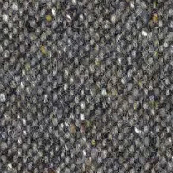 Close-up of the WIGENS Ivy Contemporary Donegal Tweed Cap in dark grey melange, featuring a textured woven fabric with small, tightly packed loops, accented by flecks of white and yellow—evoking the classic Donegal Tweed flat cap style.