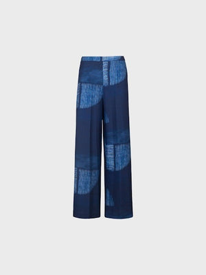 The SANDRO FERRONE - PRINTED PANT features wide legs in lightweight navy fabric, with a light blue abstract print and subtle vertical stripes on a pale gray background.