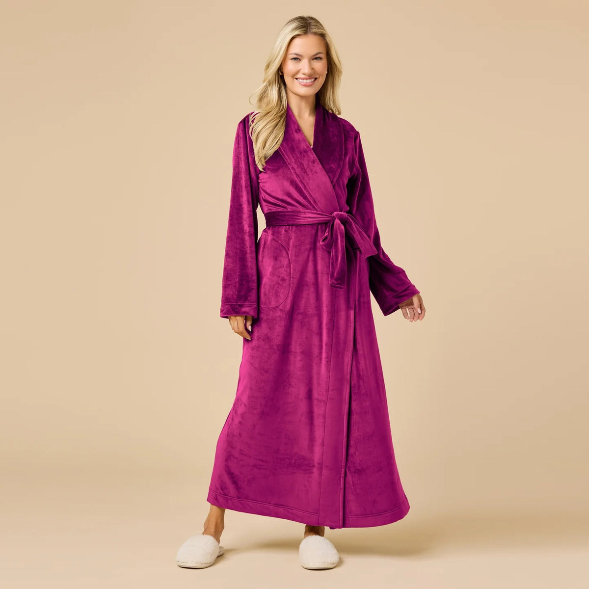 A person wearing a beige SOFTIES - SERENITY WRAP ROBE featuring a wrap silhouette with a tie waist and side pockets.
