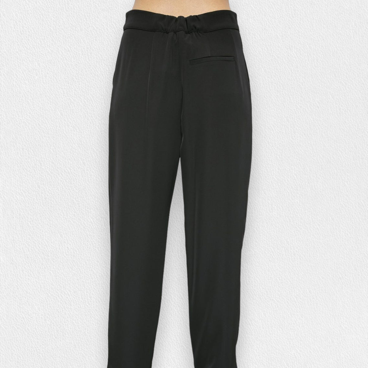 A person is wearing the MEIMEIJ - DRAWSTRING TROUSER PANT from the brand MEIMEIJ. These black, high-waisted trousers feature a loose fit and are made from a blend of polyester and elastane, complete with a tie belt. The image is taken from the waist down, showcasing the trousers in full against a plain white background, with the person&#39;s feet partially visible at the bottom.