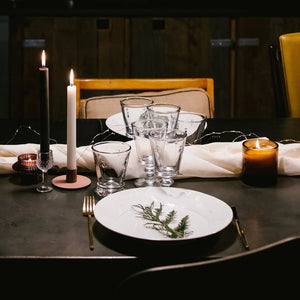 The LA ROCHERE BEE WATER GLASS, with its embossed Napoleonic bee, rests on a sunlit table beside a green lime drink, fresh cantaloupe slices, and white flowers for an effortlessly elegant display.