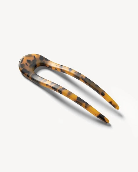 A smooth, black MACHETE - FRENCH HAIR PIN with two prongs, crafted from Italian acetate by MACHETE, rests on a plain white surface.