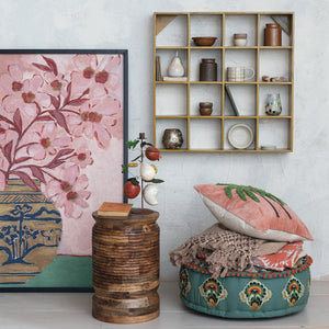Introducing the WOOD FRAMED FLORAL WALL ART - PINK FLOWERS IN CHINOISERIE VASE from CREATIVE COOP. This oversized wall decor showcases a painting of pink flowers with red stems arranged in a decorative chinoiserie vase adorned with an intricate landscape pattern of trees, hills, and water. Set against a background that transitions from light pink above to green below, this elegant piece is beautifully framed in black wood, making it a striking addition to any space.