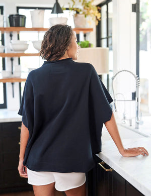 The FRANK & EILEEN Audrey Funnel Neck Capelet in British Royal Navy is a simple, loose-fitting dark navy blue t-shirt. Made from 100% cotton fleece, it features a high neckline and short sleeves with a boxy, relaxed silhouette against a white background.