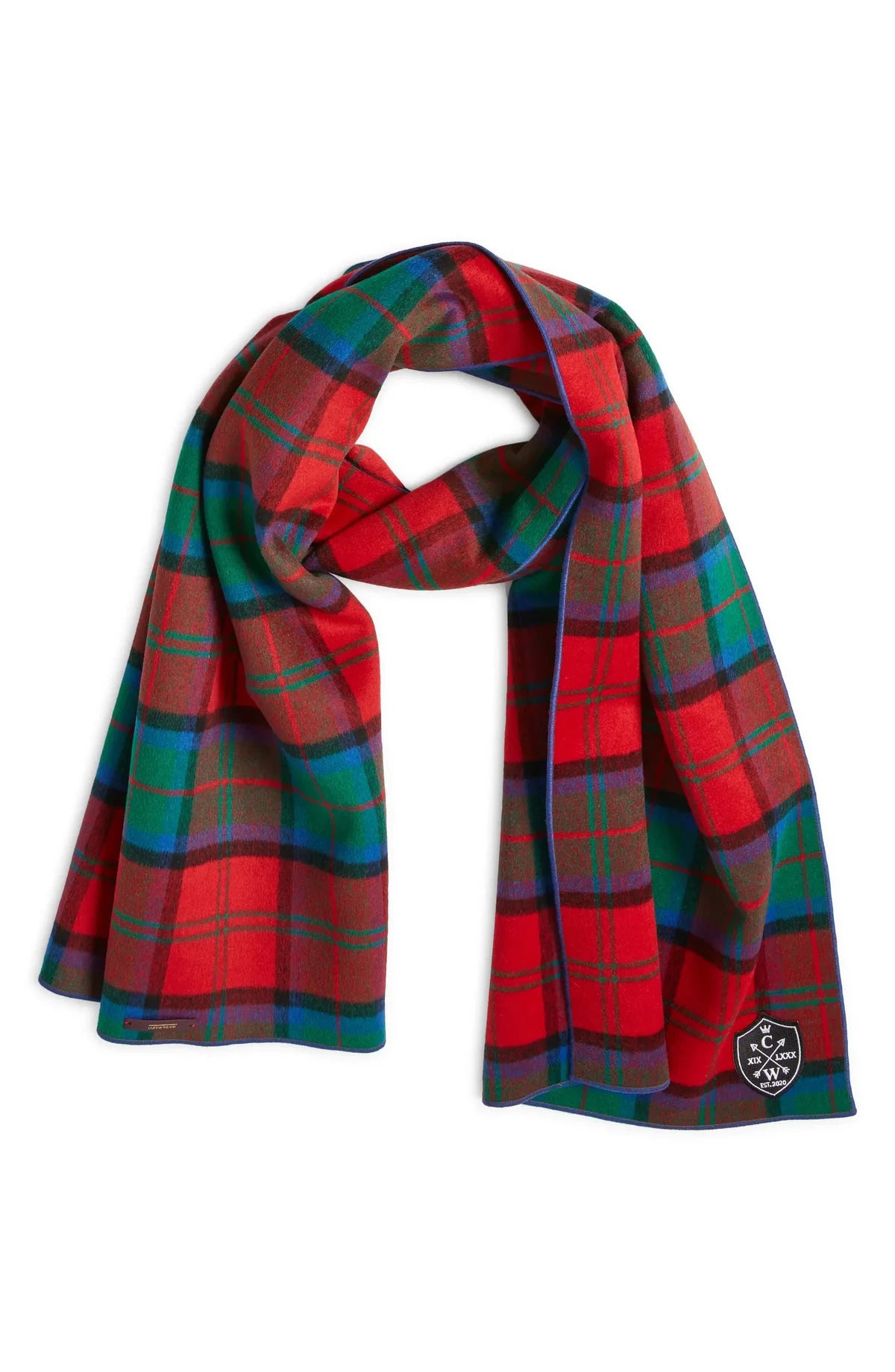 The CLIFTON WILSON - RED MULTI PLAID WOOL SCARF by CLIFTON WILSON is a premium wool accessory with a red, green, blue, and yellow plaid pattern and an embroidered black patch in the corner.