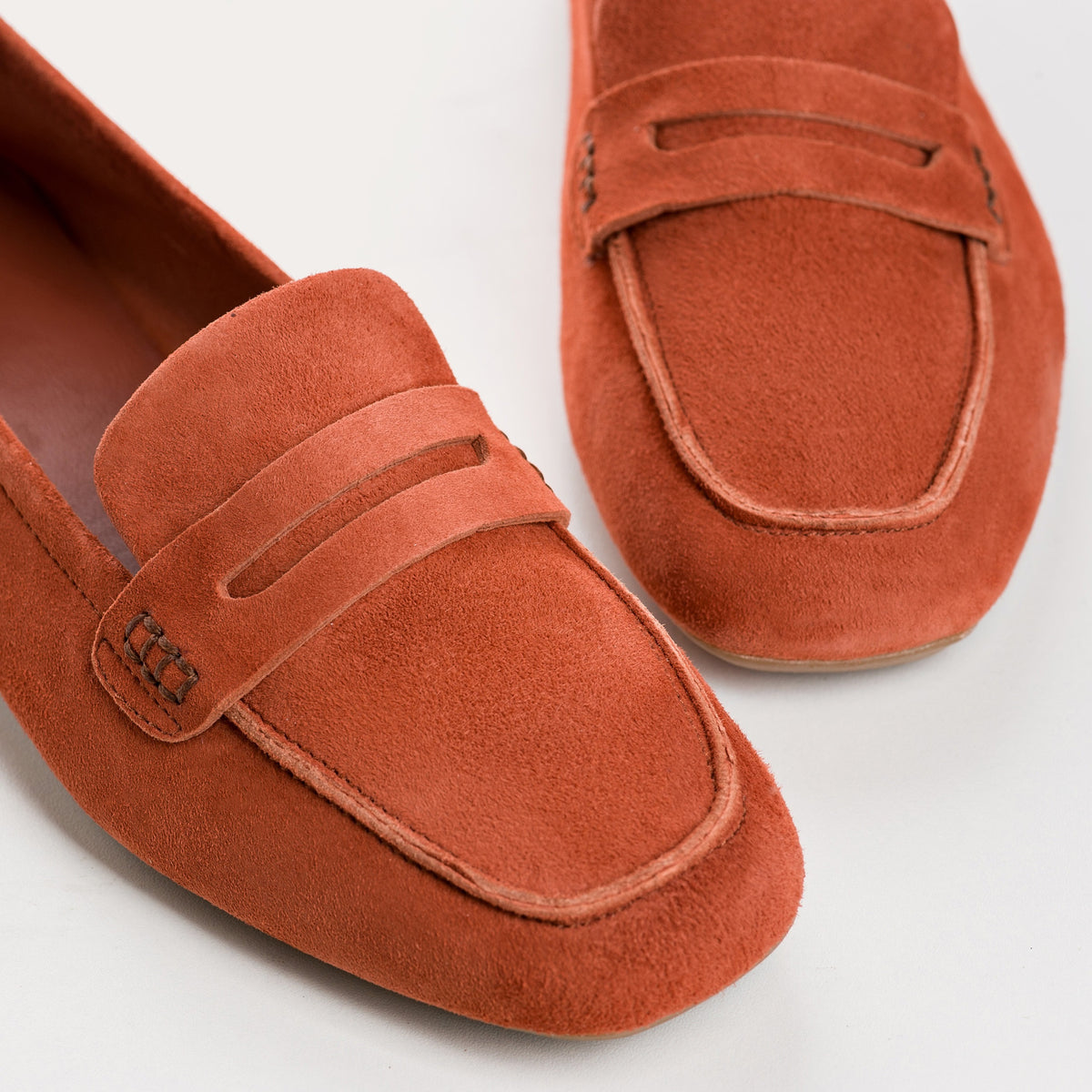 Top view of the REQINS - HEMA Suede Loafer in Briques, featuring a penny strap and visible stitching, highlighting the refined design of women’s loafers by REQINS against a plain white background.