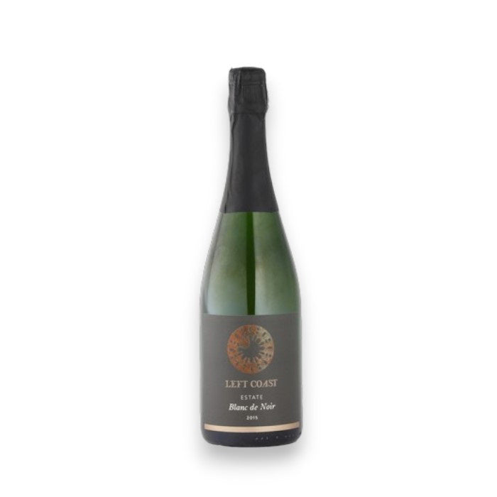 A bottle of LEFT COAST CELLARS BLANC DE NOIRS BRUT 2017 SPARKLING WINE by WINE: AMERICAN PREMIUM BEVERAGE features a dark circular label with gold text, set on a white background, and is made in the Willamette Valley using méthode champenoise.