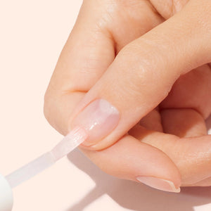 A clear glass bottle of MANUCURIST INC MANICURIST - S.O.S. NAIL MASK featuring pink liquid, a white cap, and a green label. This hydrating night care formula is designed to repair and restore damaged nails.