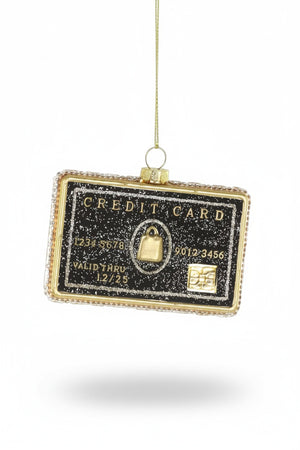 The CODY FOSTER BLACK CREDIT CARD is a 3.5-inch glass Christmas tree ornament, shaped like a black and gold glittery credit card with raised numbers, a chip, and a gold hanging string.