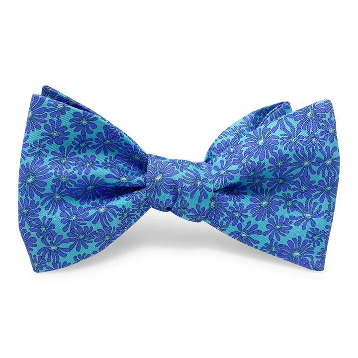 The BIRD DOG BAY PETER-BLAIR Zinnia Silk Bow Tie in aqua and purple features a floral print, is handmade with an adjustable neck for a perfect fit, and is displayed against a white background.