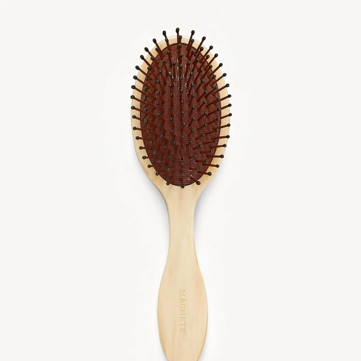 The MACHETE Everyday Detangling Hair Brush in Alabaster features an ivory marbled Italian acetate design, oval head, and curved handle with concealed bristles, shown from above on a plain white background.