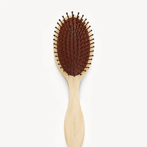 The MACHETE Everyday Detangling Hair Brush in Alabaster features an ivory marbled Italian acetate design, oval head, and curved handle with concealed bristles, shown from above on a plain white background.