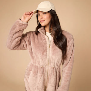 A woman wearing a cream SOFTIES - DREAMPLUSH DOUBLE ZIP JACKET / TUNIC with a cinched waist, paired with wide-leg denim culottes for cozy velvety softness.