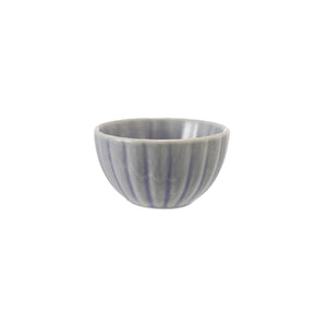 The CREATIVE COOP STONEWARE RIBBED BOWL IN LIGHT BLUE is a small, round bowl with vertical ridges and a reactive glaze. Measuring 2" tall by 3.5" wide, it's perfect for farmhouse kitchen decor and is shown centered on a white background.