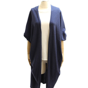 A mannequin showcases the MERSEA - CHELSEA KIMONO, a soft, loose-fitting navy blue short-sleeve cardigan by MERSEA, layered over a plain white top and displayed on a white background.