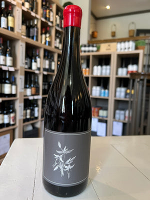 A bottle of ARNOT ROBERTS TROUSSEAU 2024 red wine featuring a red wax seal and a grey label with a white botanical illustration.