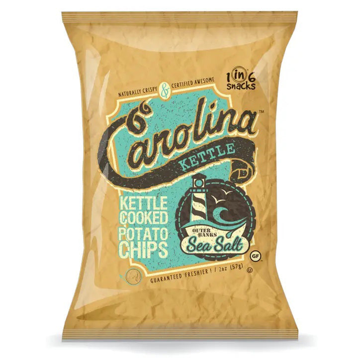 A bag of CAROLINA KETTLE - SEA SALT CHIPS 5OZ by 1 IN 6 SNACKS. The packaging is brown and beige with blue and black text. The bag mentions it contains 5 ounces (142g) of crispy, certified-quality kettle chips and proudly highlights that they are gluten-free and kosher.