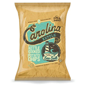 A bag of CAROLINA KETTLE - SEA SALT CHIPS 5OZ by 1 IN 6 SNACKS. The packaging is brown and beige with blue and black text. The bag mentions it contains 5 ounces (142g) of crispy, certified-quality kettle chips and proudly highlights that they are gluten-free and kosher.