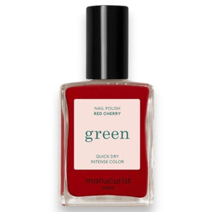 A close-up of the MANUCURIST - GREEN™ NAIL POLISH IN RED CHERRY brush, surrounded by glossy vegan polish from MANUCURIST INC, creating smooth ripples on the vibrant red surface.