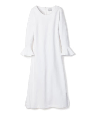 A long-sleeved white PETITE PLUME - LUXE PIMA NIGHTGOWN, crafted from Peruvian Pima cotton, hangs against a white background. The nightgown features a round neckline and flared sleeves with ruffled cuffs. With a subtle quilted effect and simple, elegant design, it exudes the charm of luxurious sleepwear.